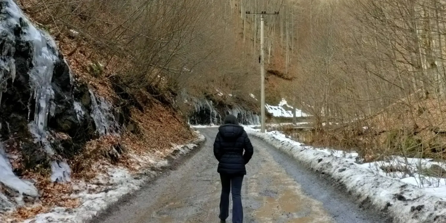 Çamurlu dağ yolunda arkası dönük kadın